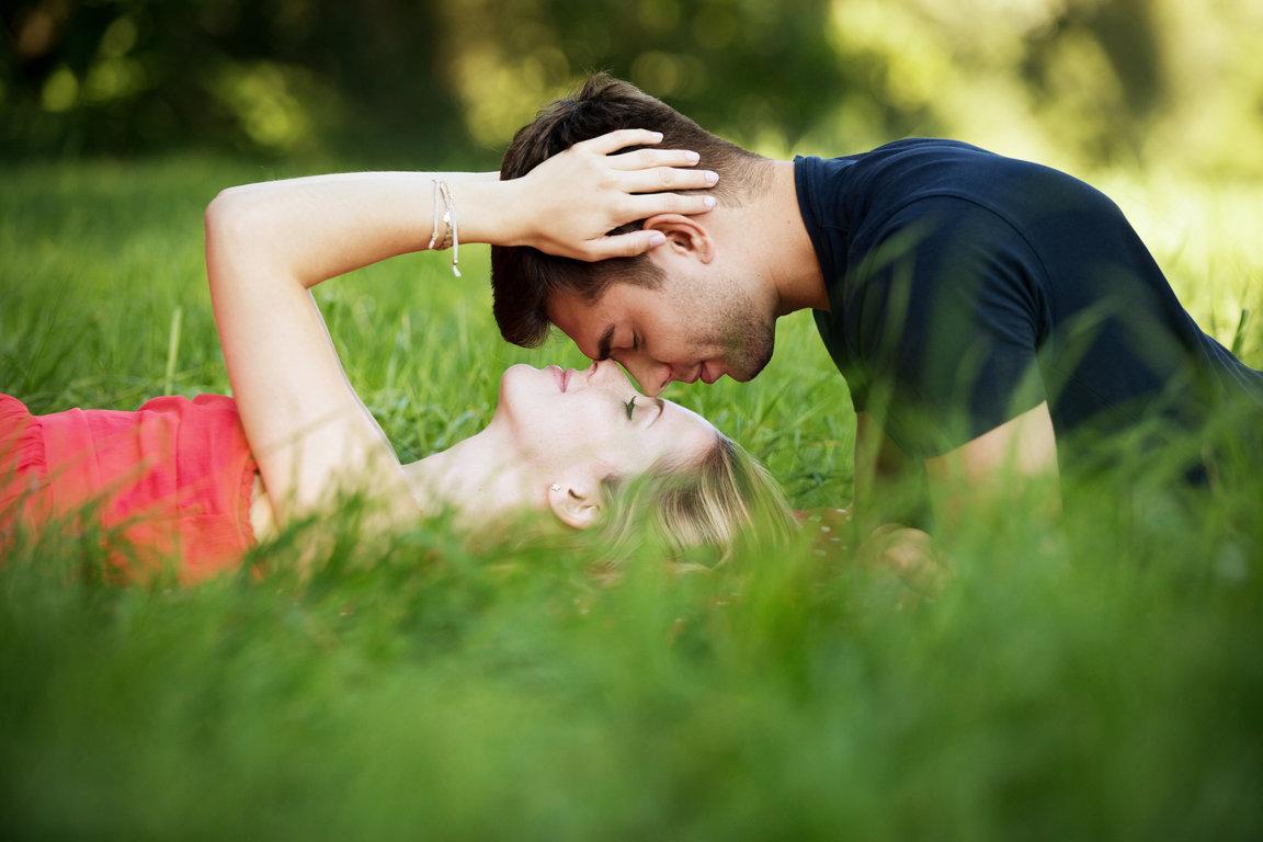 Young couple dating in the park and lying on the grass