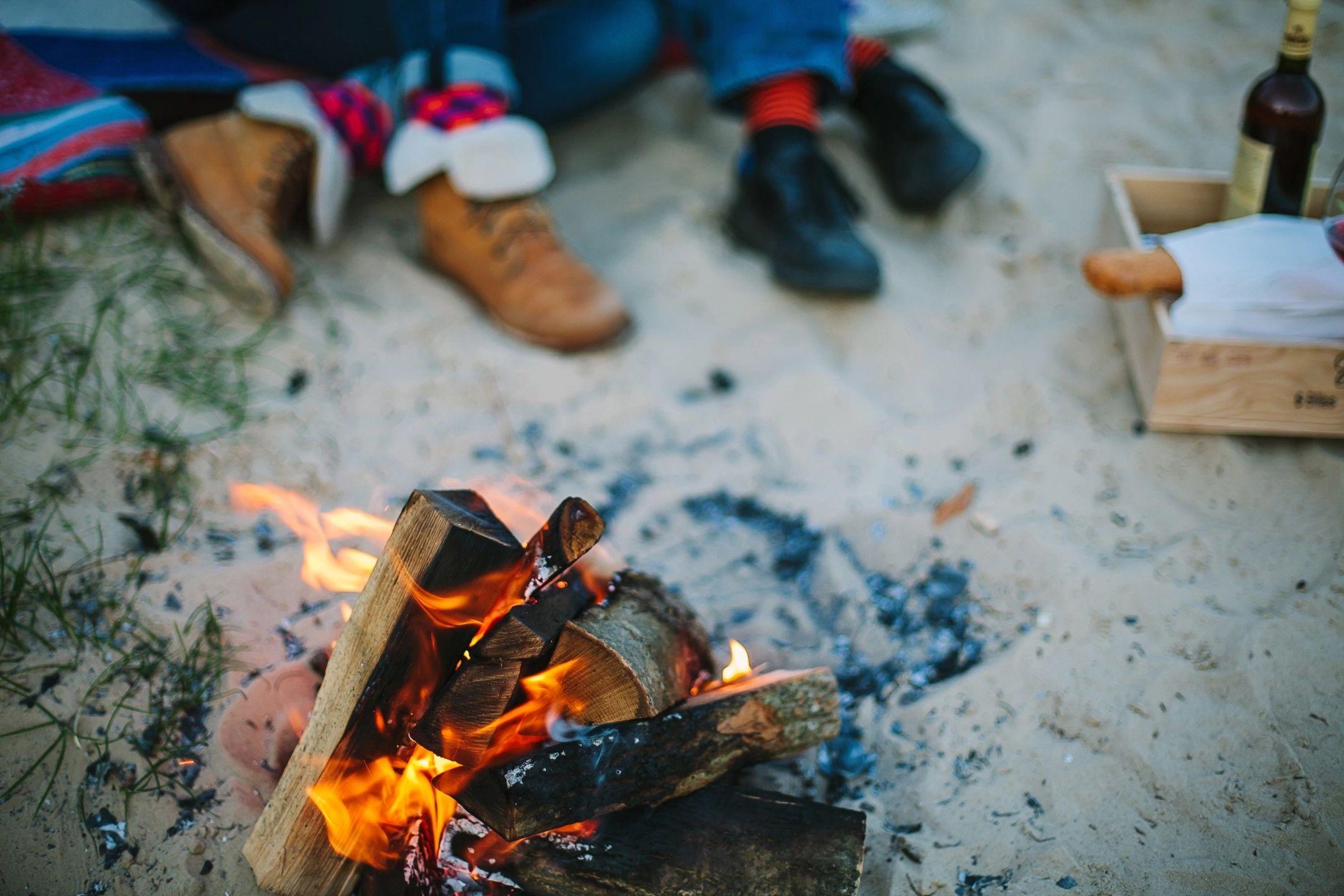 Young couple dating on the beach over bonfire