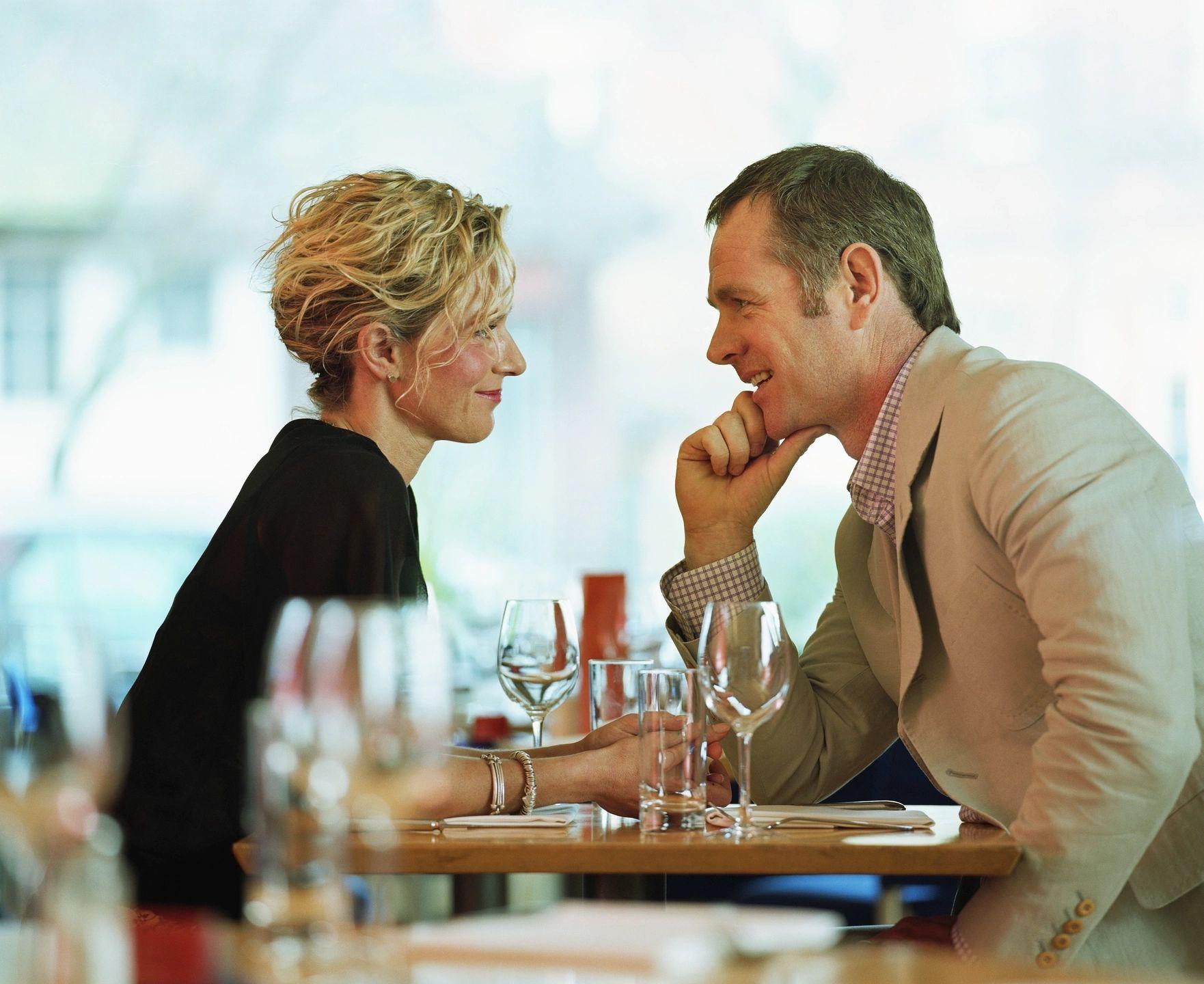 Elite singles staring and chatting with each other in a restaurant